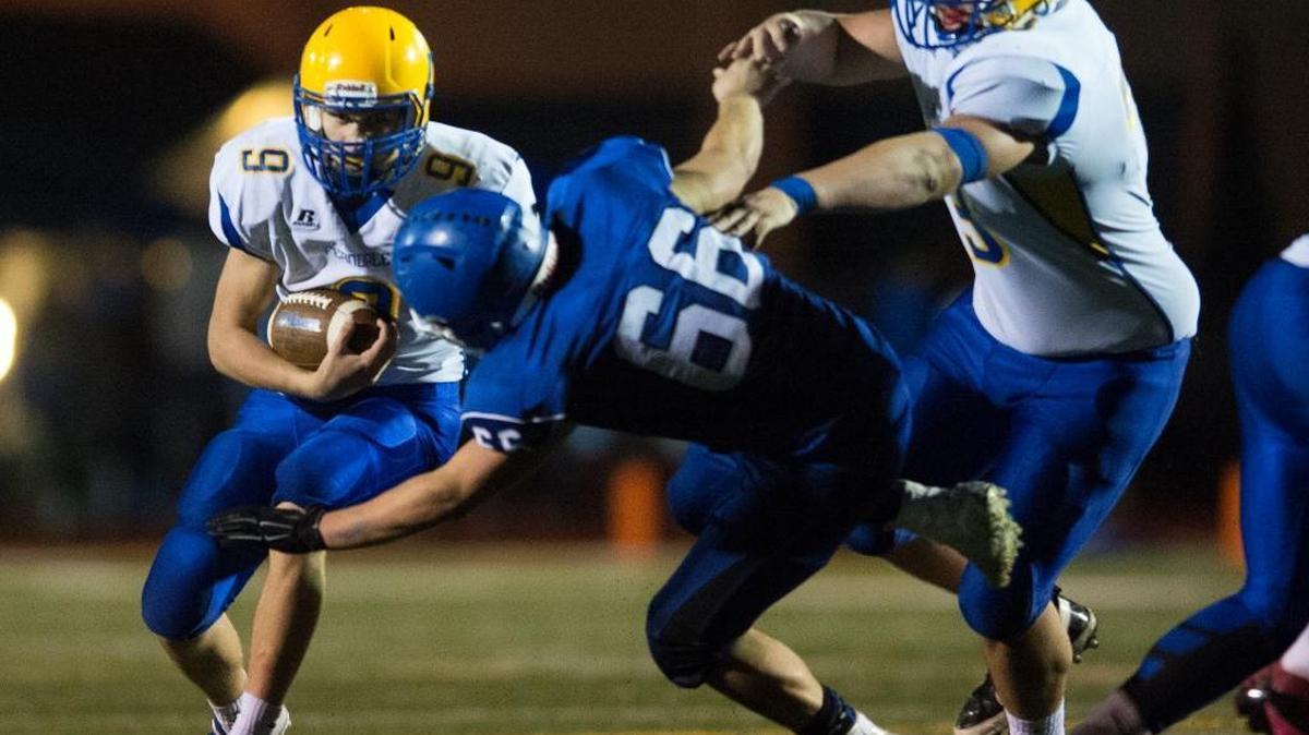 Ferndale's Justice Powell looks to run through a hole from a big block by teammate Nick Bartel on Sedro-Woolley's Joey Pittis on Thursday, Oct. 29, at Sedro-Woolley High School. Ferndale won the game 20-16.