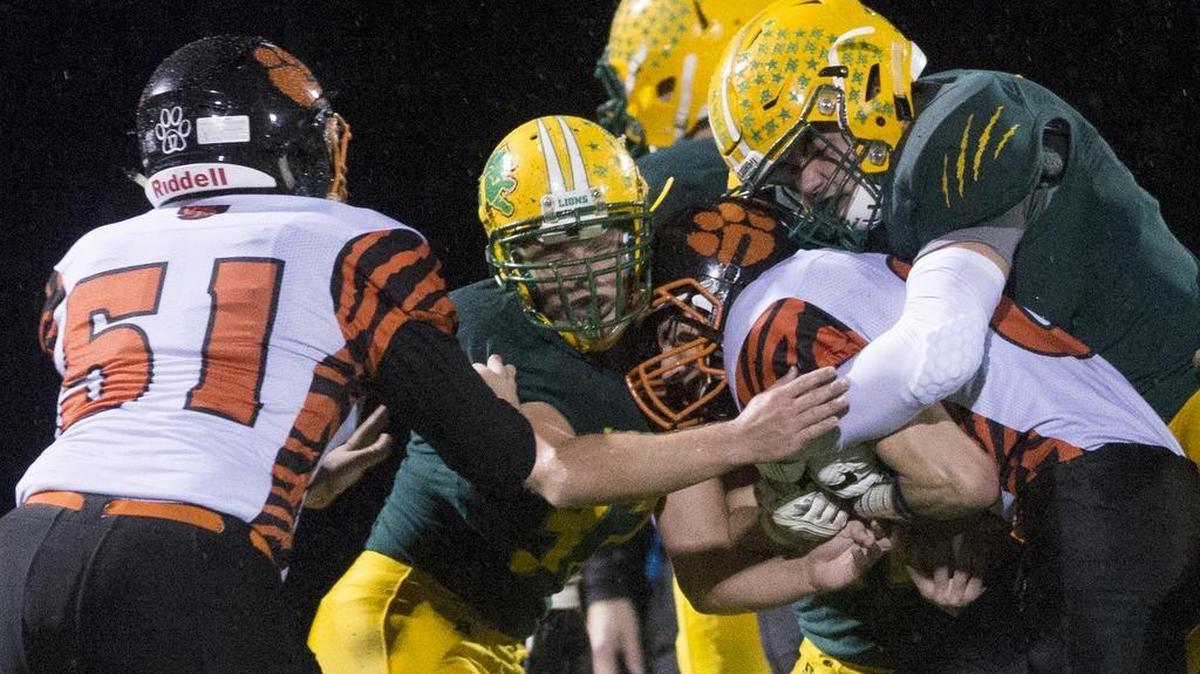 Lynden defenders tackle Granite Falls’ Camden Landrum in a 2A bi-district playoff game Saturdayat Civic Stadium in Bellingham.