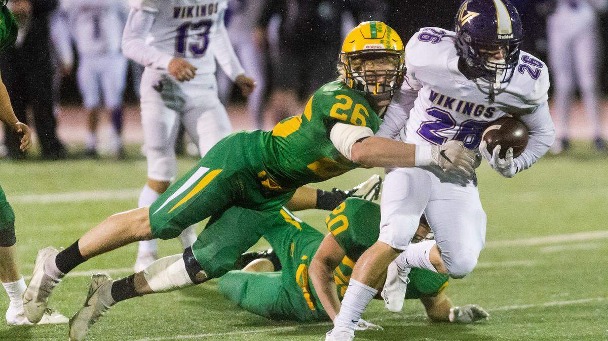 Lynden linebacker Taivin VanDalen (26) stops North Kitsap running back Karsen Walsh (26) as he breaks the line of scrimmage for a short gain during the first quarter in the 2A state football semi-final playoff on Saturday evening Nov. 27, at Civic Stadium in Bellingham. The Lynden Lions defeated the North Kitsap Vikings 15-10 to advance to the state final.