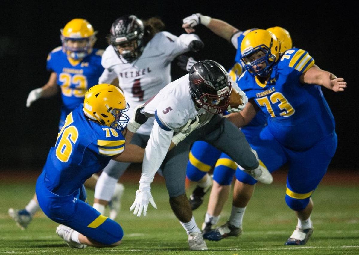 Ferndale’s Mikhail Varetskiy, left, and Darius Washington bring down Bethel’s Will Latu in the backfield on Friday, Nov. 10, at Civic Stadium in Bellingham.
