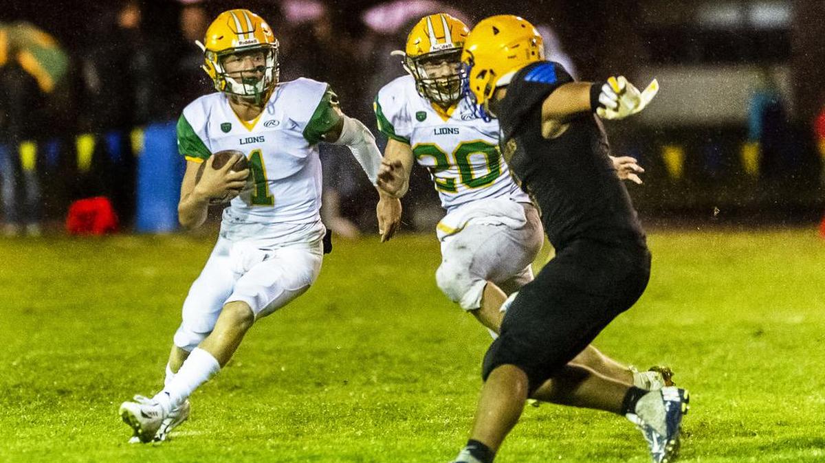 Lynden running back Steven DiLorenzo (20), right, blocks Ferndale linebacker Jazen Guillory (5) as Lynden quarterback Baylor Ayres (1), left, evades and breaks through the line of scrimmage for a big gain during the third quarter on Friday evening Sept. 13, 2019, at Ferndale High School in Ferndale, Wash. Lynden defeated Ferndale 33 to 21.