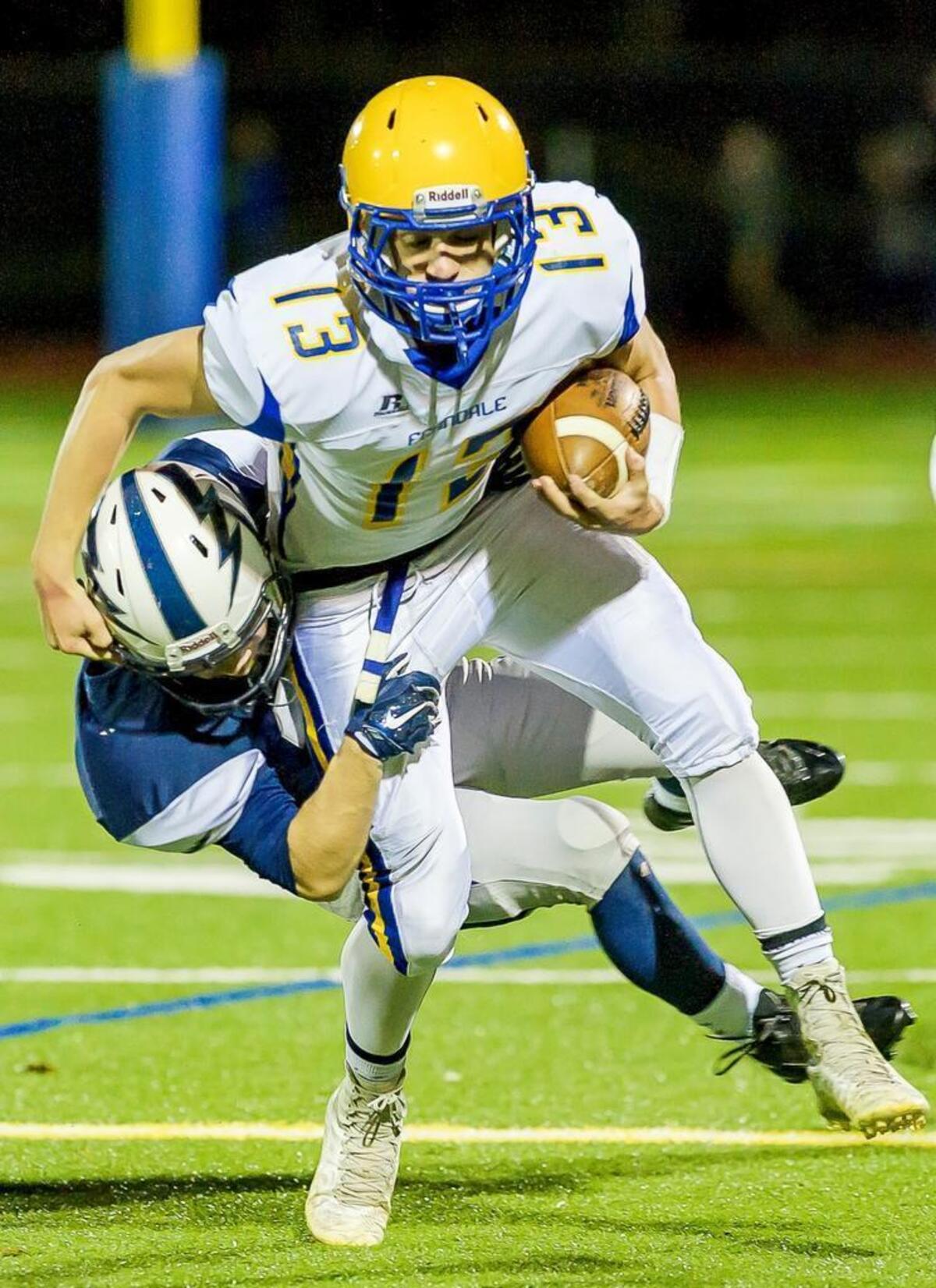 Squalicum linebacker Will Nickelson (32) tackles Ferndale quarterback James Hinson (13) for a loss of yardage early in the first quarter on Saturday evening, Oct. 10, at Civic Stadium in Bellingham.