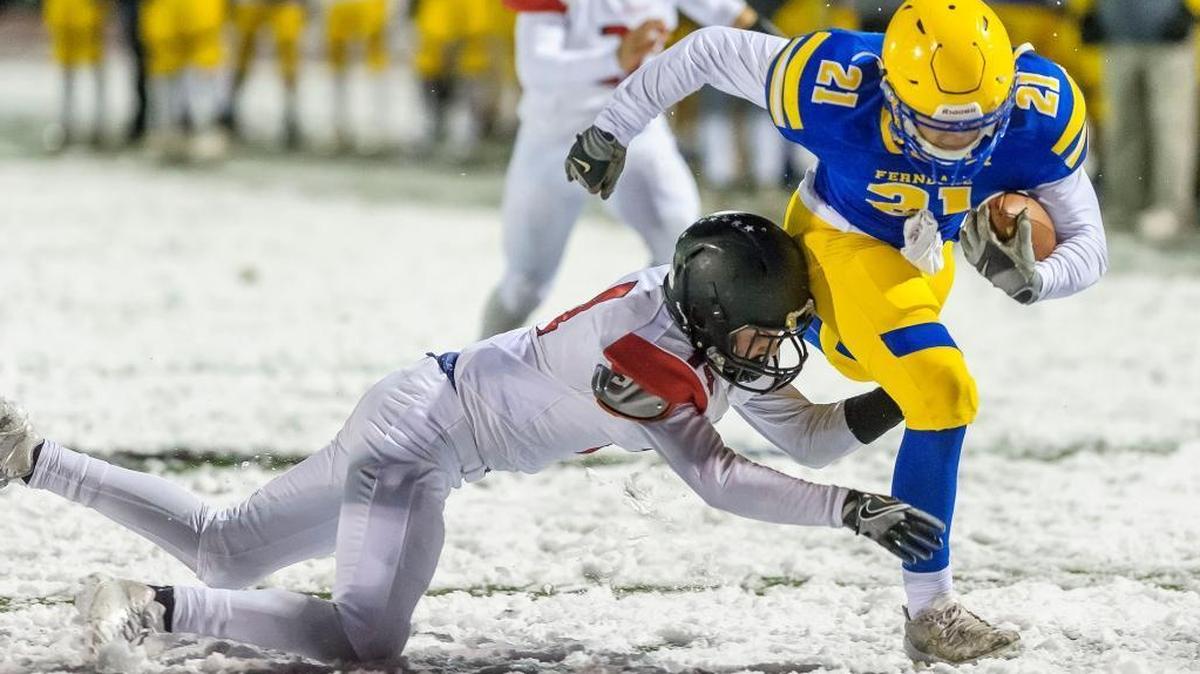 Ferndale running back Cole Semu slips the tackle of Ballard defender Owen Albert at the goal line to score a touchdown during the first quarter of the 3A district playoffs Friday at Civic Stadium.