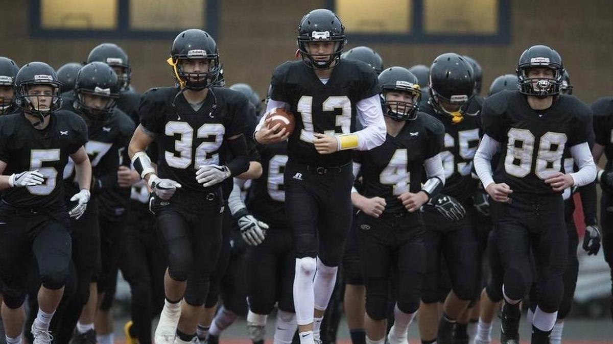 Simon Burkett (13) leads the Meridian football team onto the field at Civic Stadium for the Class 1A semifinal against La Center. Burkett was selected a WIAA Athlete of the Week for his performance in the game.