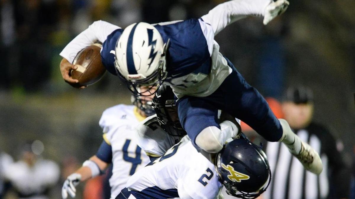 Squalicum’s Ja’Lique Martin is hit in the air while attempting to jump over Arlington’s Trevor Kazen Thursday, Oct. 26, at Civic Stadium.