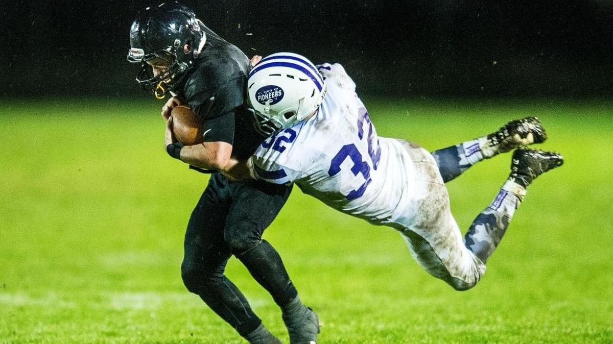 Meridian’s Cole Roberts, left, is tackled at the line of scrimmage by Nooksack Valley’s Mark Coppinger (32) early in the fourth quarter Friday, Oct. 21, at Meridian High School.