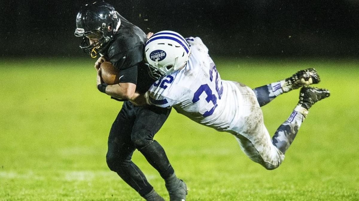 Meridian’s Cole Roberts, left, tries to shake a tackle by Nooksack Valley’s Mark Coppinger Oct. 21.