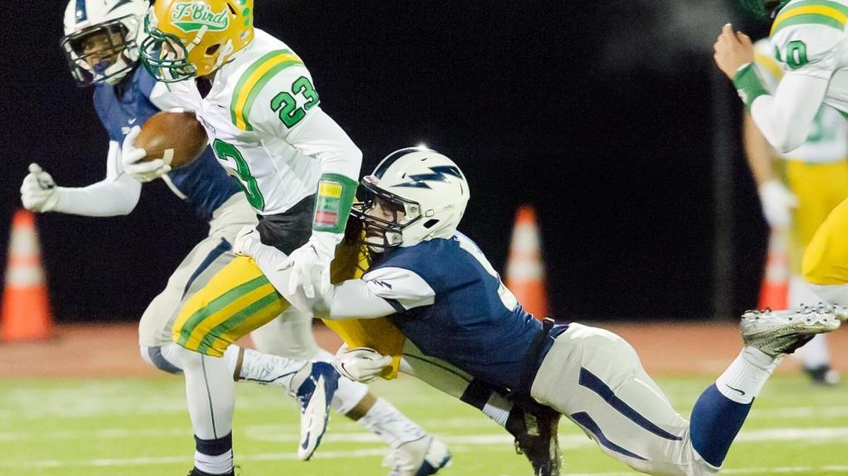Squalicum's Ben Peterson (5) tackles Tumwater's Noah Andrews (23) preventing a touchdown during the first quarter Saturday, Nov. 21, at Civic Stadium.