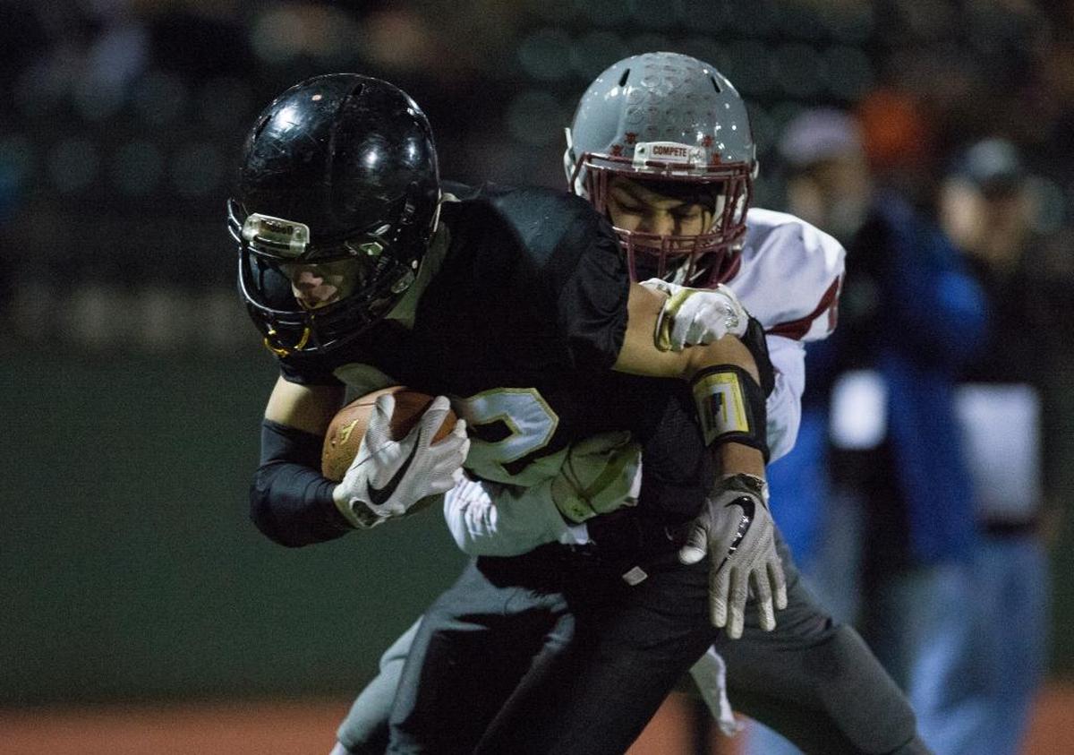 Meridian’s Tony Schleimer, left, scores a touchdown with Hoquiam’s Marques Rivera clinging to his back Nov. 11 in Bellingham.
