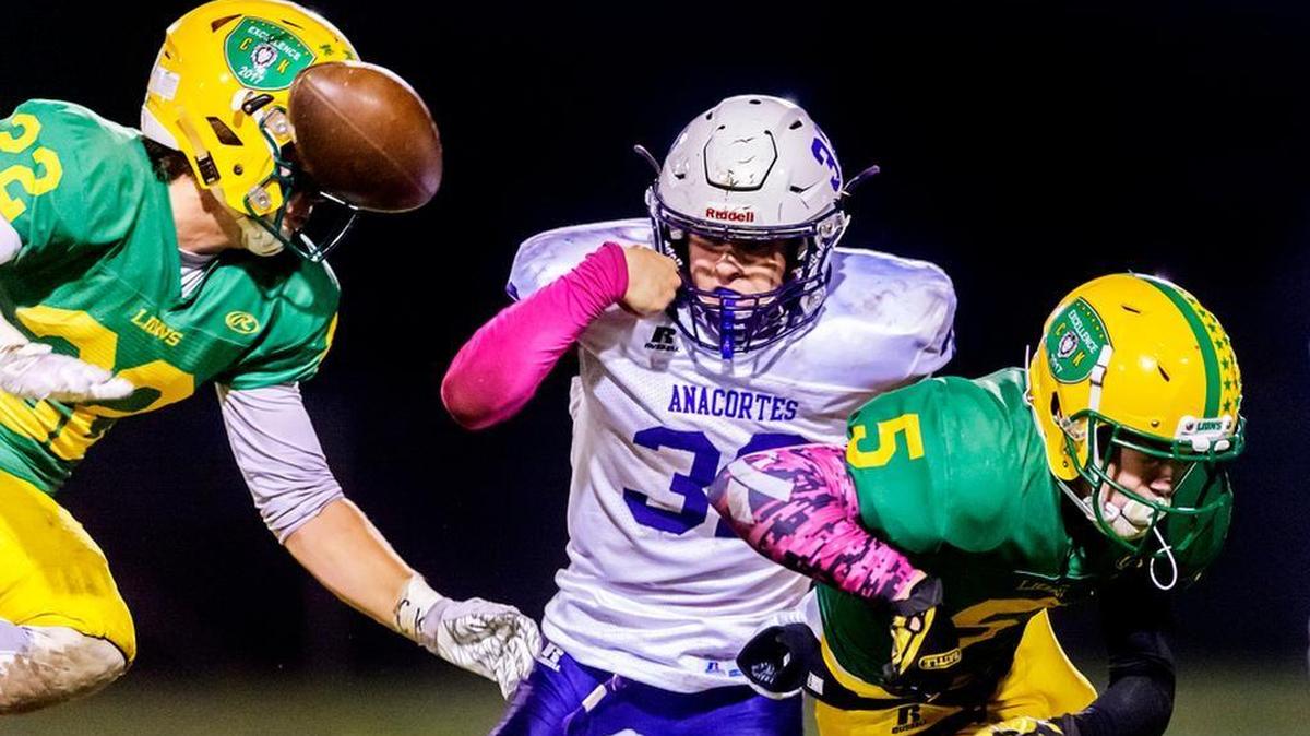 Lynden defensive back Bo Bovenkamp, right causes Anacortes running back Peyton Beaner to fumble as Lynden linebacker Gage Bates moves in For the tackle during the second quarter Friday, Oct. 13.