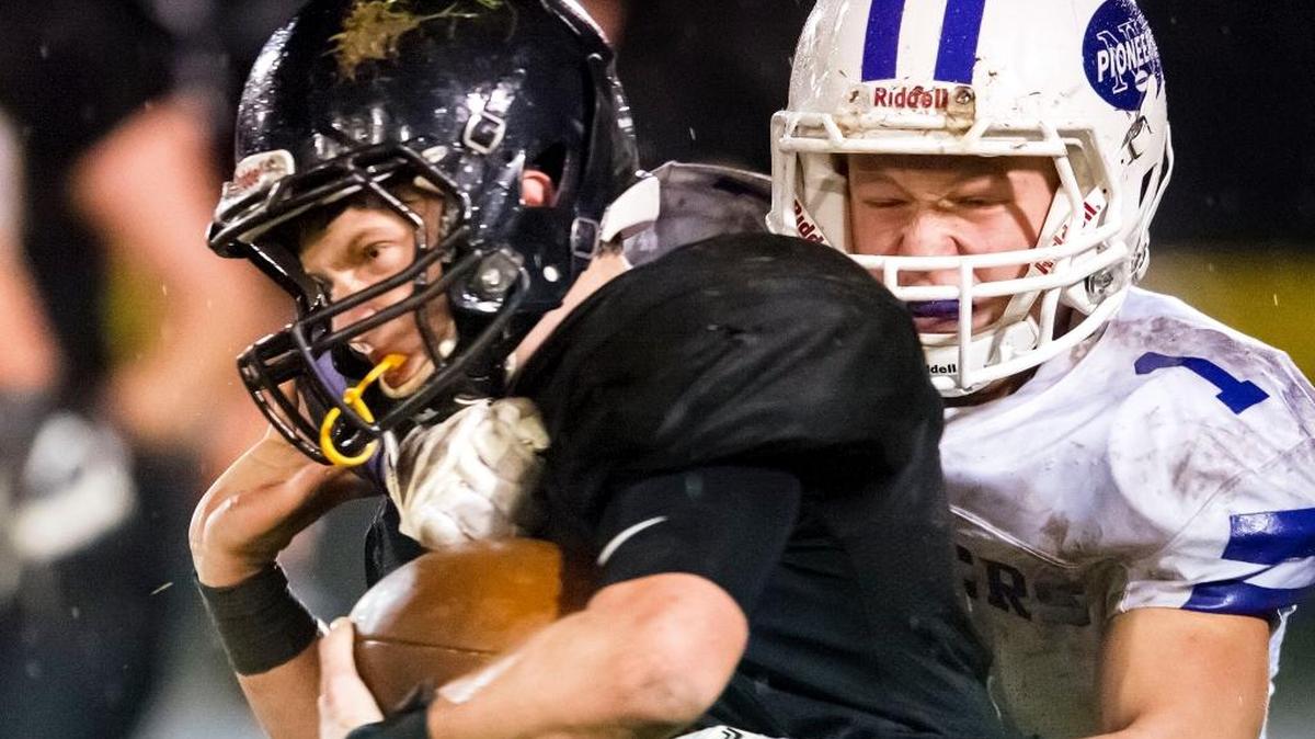 Meridian’s Cole Roberts, left, gets wrapped up by Nooksack Valley’s Jeremy Dykes late in the third quarter Friday, Oct. 21, at Meridian High School.