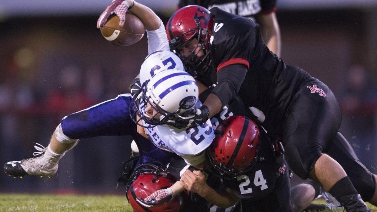 Mount Baker’s Carson Brandland, bottom, Carson Engholm, right, and Noah Rathjen, top, tackle Nooksack Valley’s Tre Silva Sept. 23 at Mount Baker High School. The Mountaineers face La Center in the Class 1A state quarterfinals Saturday at Woodlannd.