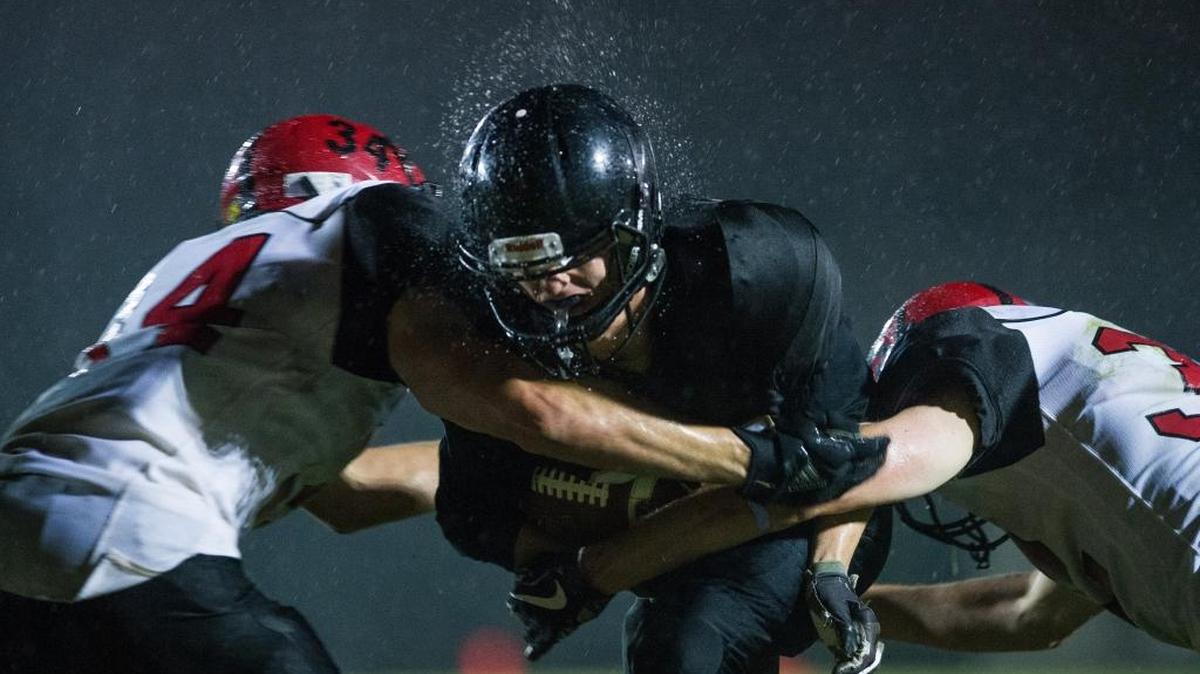 Meridian wide receiver Lukas Hemenway, center, fights through two tackles to score a touchdown against Mount Baker in the fourth quarter on Friday night at Meridian High School.