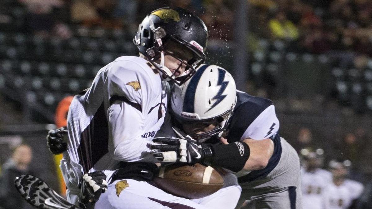 Squalicum’s Jacob Burgoon, bottom, and Brian Pullman, right, sack Lakewood’s Austin Lane during a 2015 2A Northwest District playoff football game at Civic Stadium.