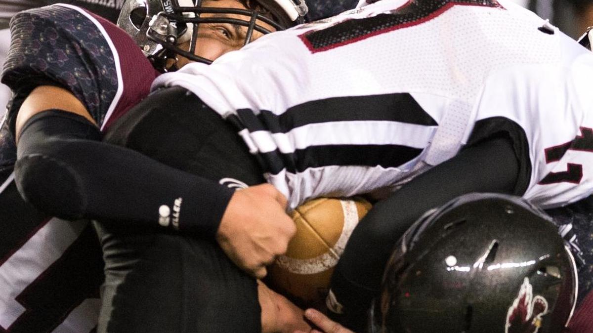 Lummi’s Dashawn Lawrence, left, and teammate John Ballew sandwich Almira-Coulee-Hartline's Dallas Isaak on Friday, Dec. 4, at the Tacome Dome.