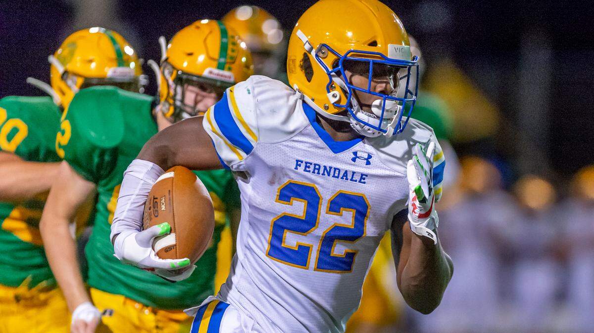 Ferndale running back Isaiah Carlson (22) breaks free of a pack of Lynden defenders to run for a touchdown during the fourth quarter on Friday evening Sept. 10, 2021, at Lynden High School in Lynden, Wash. Ferndale defeated Lynden 35 to 25. (photo Paul Conrad for the Bellingham Herald)