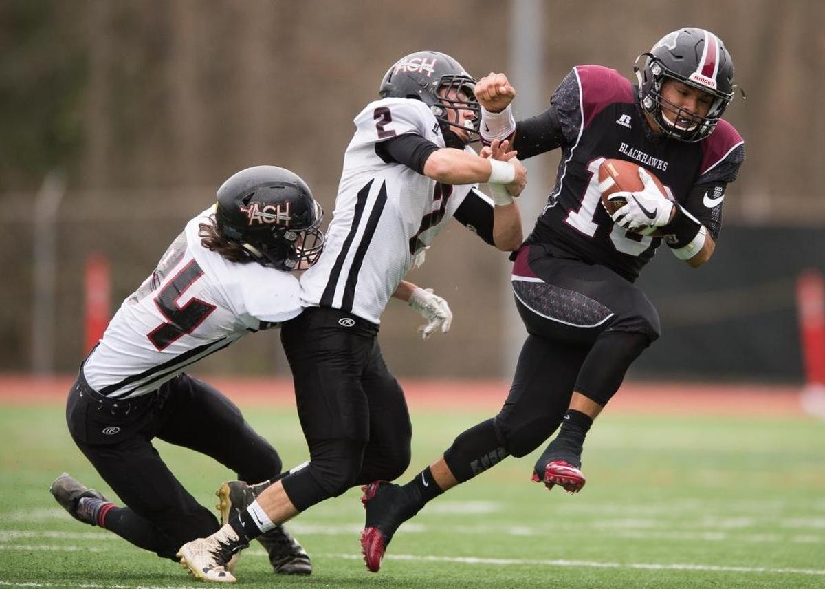Almira-Coulee-Hartline’s Payton Nielsen, left, and Parker Zappone, center, chase down Lummi’s Dashawn Lawrence on Saturday, Nov. 25, at Civic Stadium in Bellingham.