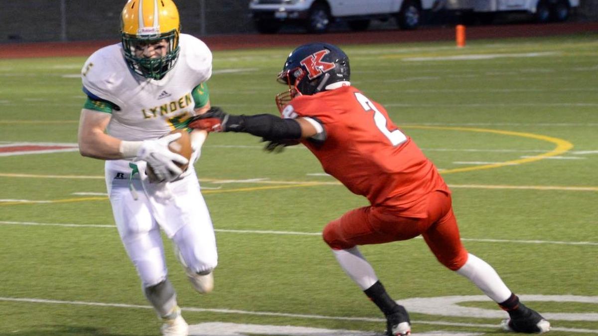 
Lynden’s Noah King, left, runs the ball against King’s on Friday, Sept. 4, in Shoreline.
