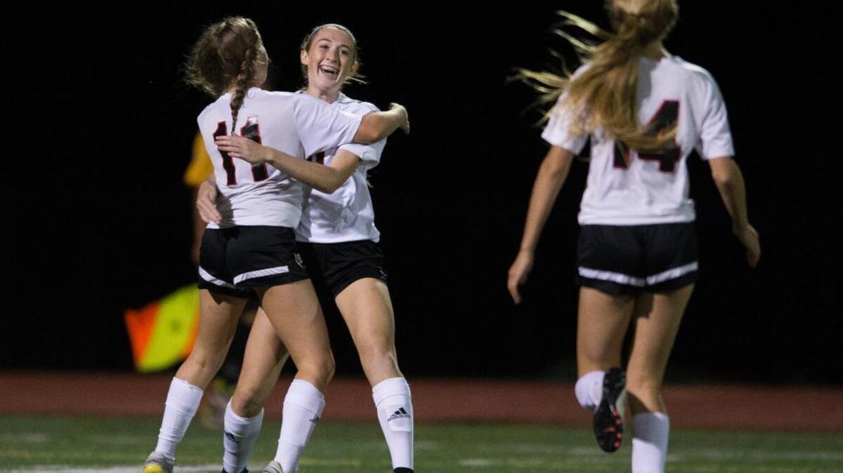 Bellingham’s Hannah Hodge celebrates with teammate Jillian Langei (11) and Mia Sivret (14) after Hodge’s second-half goal in a 3-2 win over Squalicum Tuesday at Civic Stadium.