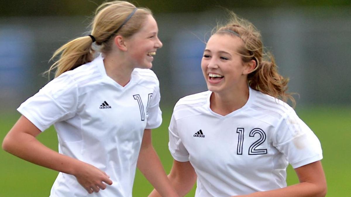 Lynden Christian's Shaye Brandsma (14) and Haley Hollander (12) celebrate Hollander's goal during their 3-0 victory over Cedar Park Christian on Monday, Oct. 26. Hollander scored twice.