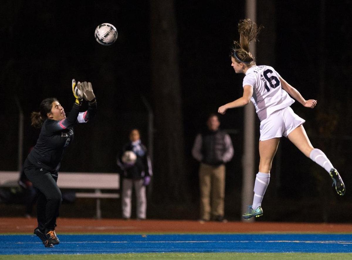 Squalicum's Kim Dorr heads the ball past Ridgefield's Sarah Kaufman for a goal Saturday, Nov. 21, at Shoreline Stadium.