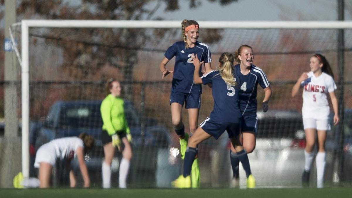 Lynden Christian’s Emily Mellema (2), Emily Roetcisoender (5) and Bailee DenBleyker celebrate during the Class 1A Northwest District Tournament championship game Oct. 28 at at Whatcom Community College in Bellingham.