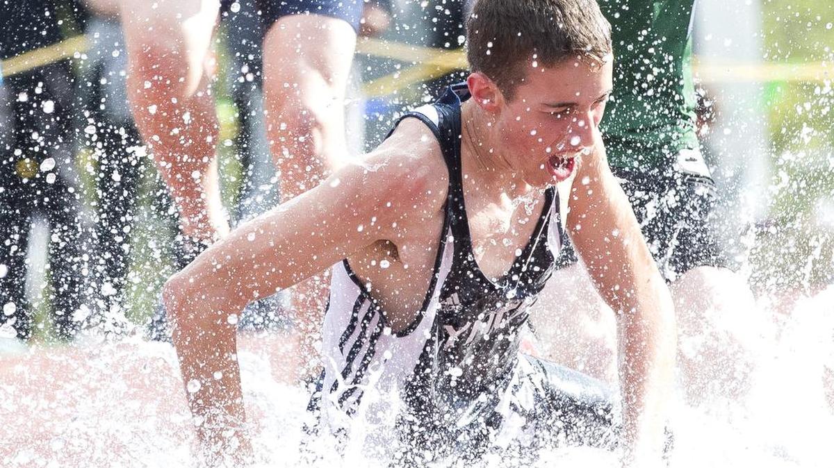 Lynden Christian's Brooks DeWaard crashes into the water pit during the boys' steeplechase at the 2016 Birger Solberg Invitational on Saturday, April 9, at Civic Stadium in Bellingham.