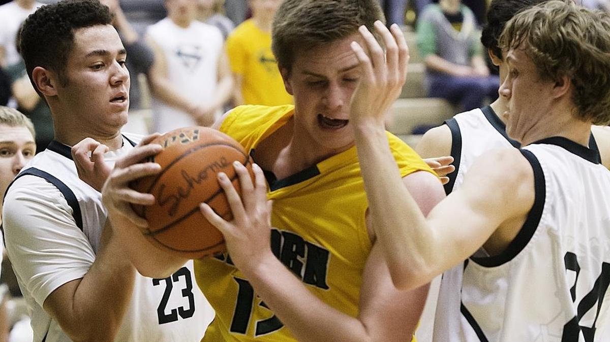 Lynden guard Sterling Somers grabs a rebound from Sehome guard Marcus Montag, left, and Tanner Clark during a game in February 2015. The Northwest and Sea-King districts announced changes for Class 2A bi-district tournament in team sports beginning this fall in girls’ soccer and volleyball.