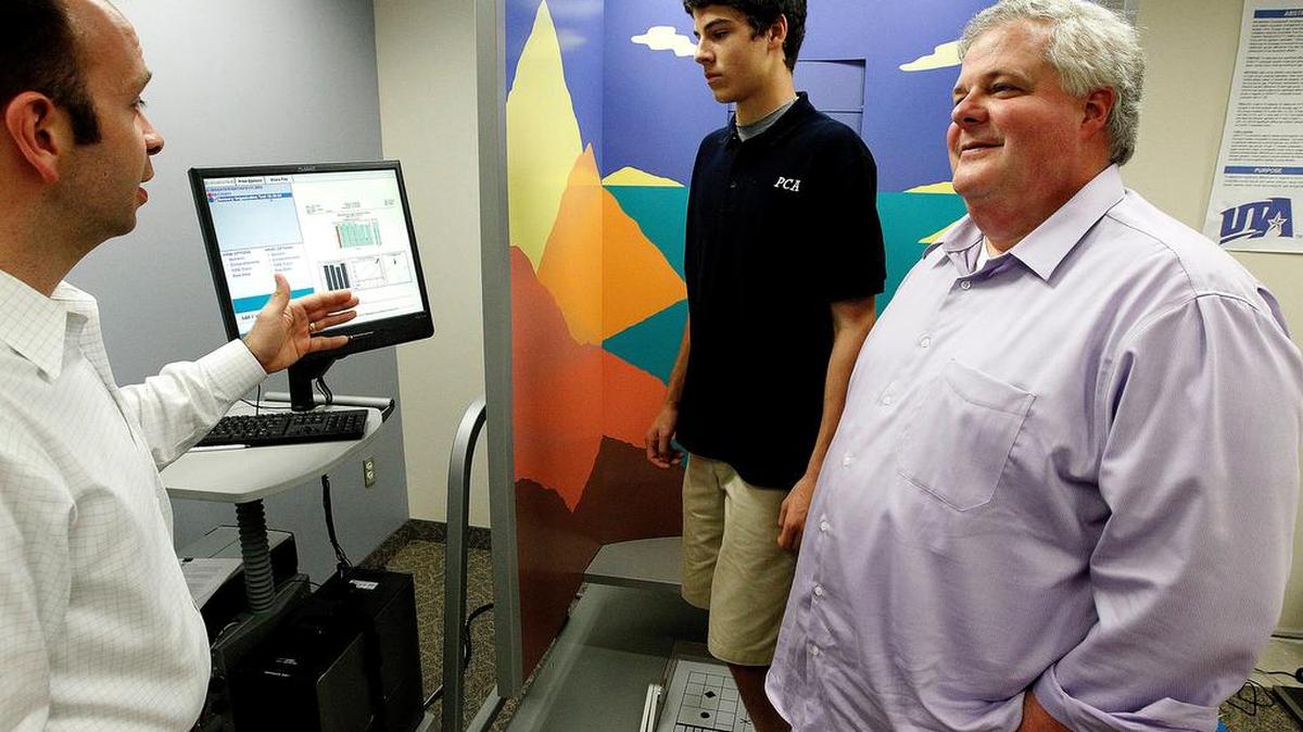 
Mason Pritcher, a high school athlete, and his father, Jay Pritcher, talk with Dr. Jacob Resch, left, who is conducting research on concussions in young athletes at the University of Texas Arlington in 2012. 
