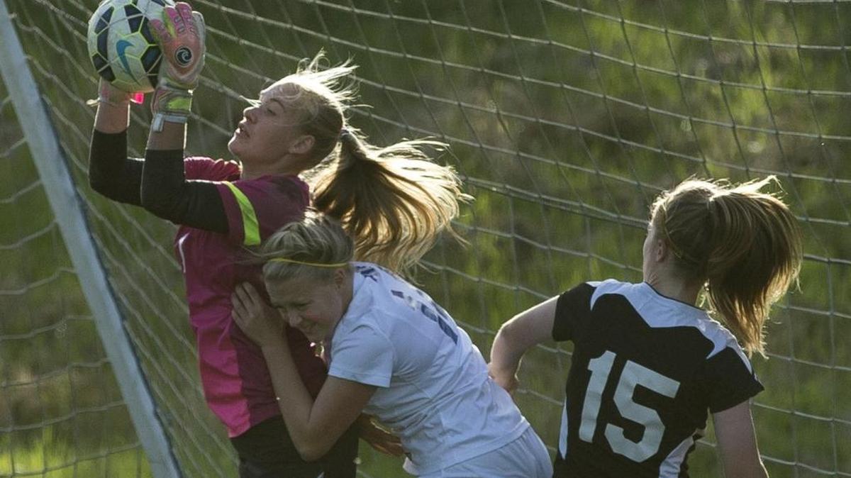 
Meridian's Sydney Gospodinovich jumps over Ferndale's Catelyn Goode to save a goal at Ferndale High School on Thursday, Oct. 16, 2014 in Ferndale. Gospodinovich has had multiple run-ins with head injuries since she joined Meridian three years ago. 

