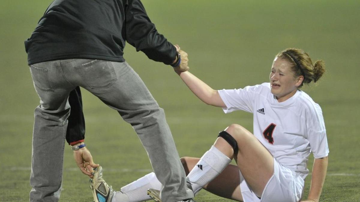 
Sehome’s Ashley Mindnich is helped up by head coach Mark Wright after she was injured leaping for a header. High school coaches, such as Wright, must now take courses about the dangers and symptoms of concussions and head injuries since the 2009 implementation of the Lystedt law in Washington state.
