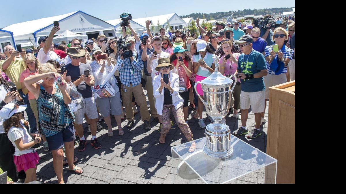 
Golf fans gather to photograph the championship trophy after opening ceremonies Sunday at Chambers Bay golf course in University Place. The tournament starts Thursday.
