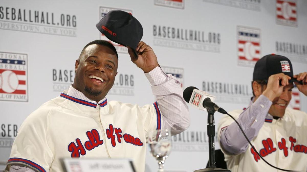 Ken Griffery Jr., left, reverses his cap after donning it backward at a news conference about his and Mike Piazza's election to baseball's Hall of Fame, Thursday, Jan. 7, 2016, in New York. Both men will be inducted into the Hall of Fame this summer. 
