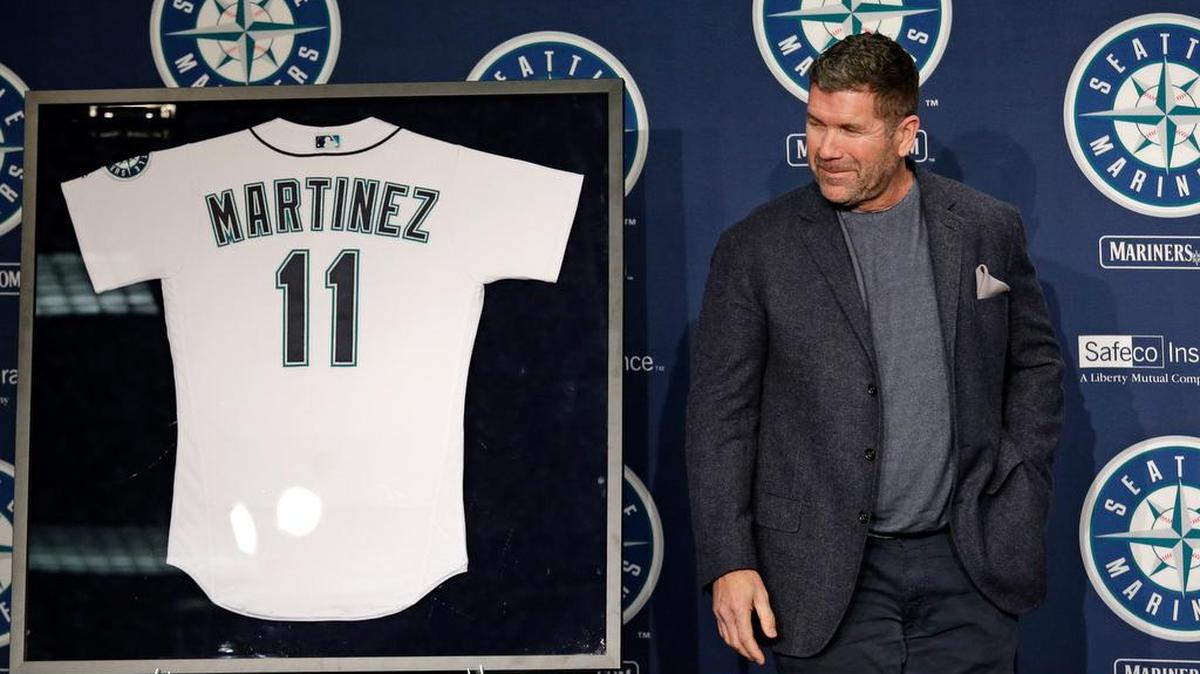 Mariners hitting coach and former designated hitter Edgar Martinez glances at a jersey framed in his honor during a news conference Tuesday in Seattle. Martinez’s number will be officially retired Aug. 12.