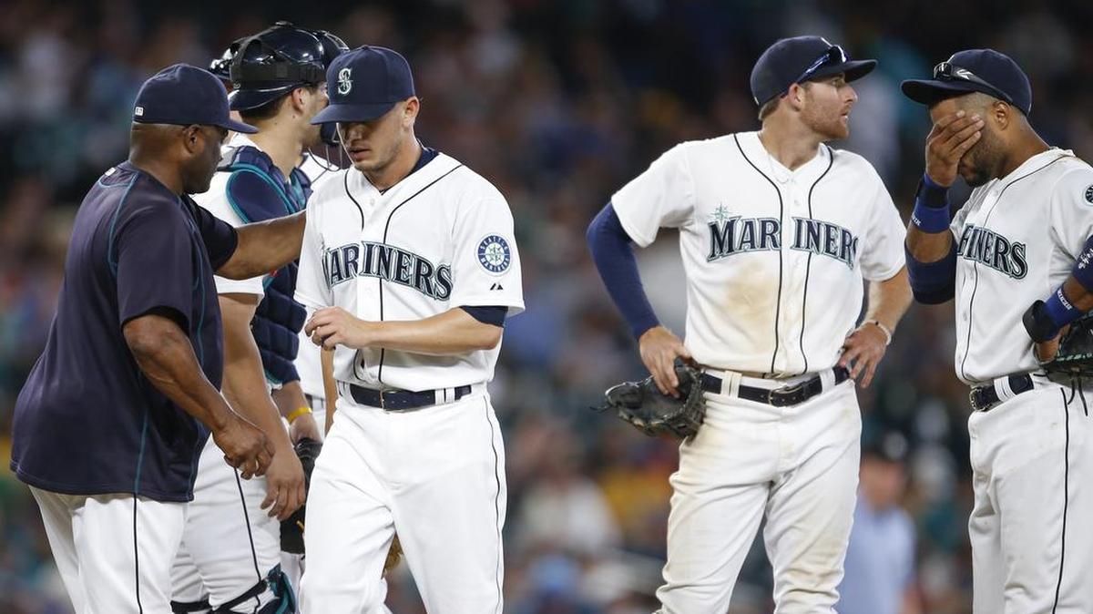 
Seattle Mariners pitcher Rob Rasmussen, third from right, walks to the dugout after being relieved by manager Lloyd McClendon, left, during the 11th inning of a game Aug. 8 in Seattle. 
