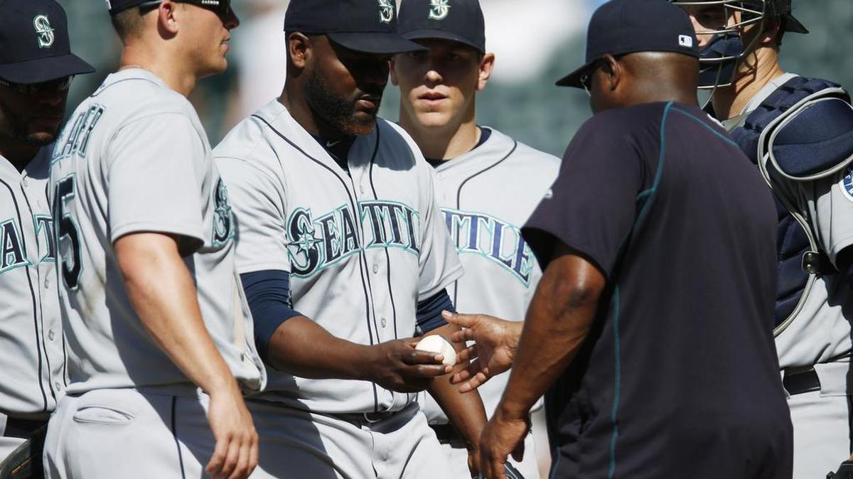 
Seattle Mariners relief pitcher Fernando Rodney, middle, hands the ball to manager Lloyd McClendon after walking Colorado Rockies pinch-hitter Daniel Descalso in the ninth inning of a baseball game, Wednesday, Aug. 5, 2015, in Denver. Colorado won 7-5 in 11 innings.

