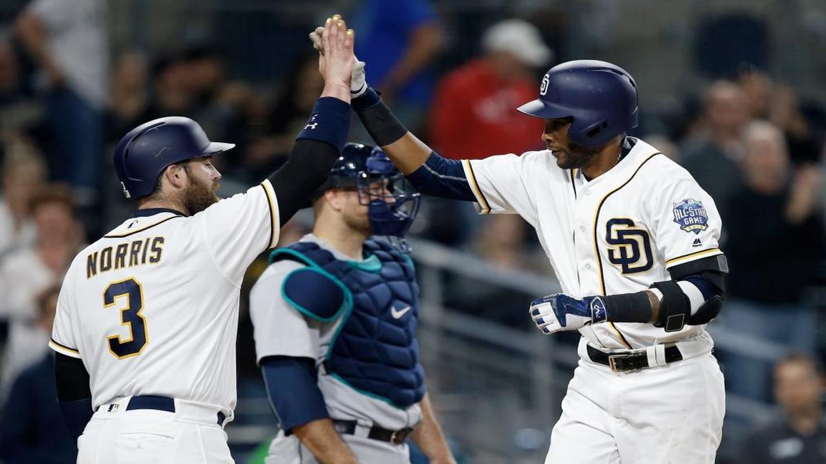 San Diego Padres' Derek Norris (3) congratulates Alexei Ramirez, right, who hit a two-run home run, his second homer of the night, near Seattle Mariners catcher Chris Iannetta, rear, during the sixth inning of a baseball game in San Diego, Wednesday, June 1, 2016.