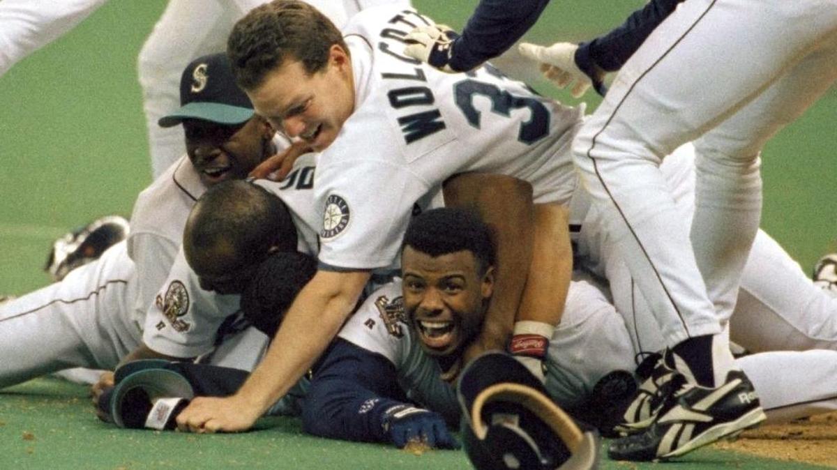 In this Oct. 8, 1995, file photo, Seattle Mariners' Ken Griffey Jr. smiles from beneath a pile of teammates who mobbed him after he scored the winning run in the bottom of the 11th inning of a baseball game against the New York Yankees in Seattle. Ken Griffey Jr. was elected into the Baseball hall of Fame on the first try Wednesday, Jan. 6, with a record vote of close to 100 percent.