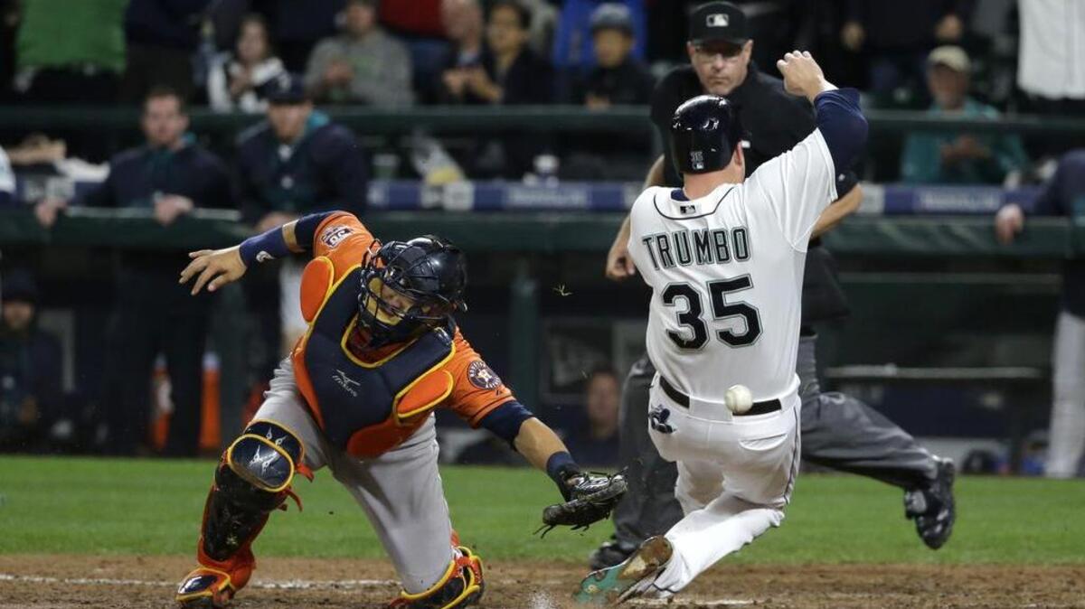 
Seattle’s Mark Trumbo, right, avoids the tag of Astros catcher Hank Conger to score on a single by Shawn O’Malley in the eighth inning. 
