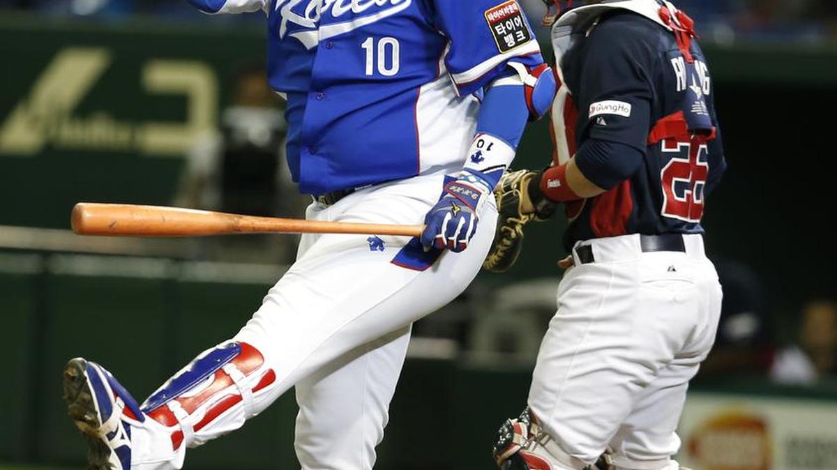 South Korea's designated hitter Lee Dae-ho (10) reacts after getting struck out in front of USA catcher Dan Rohlfing during the fourth inning of their final game at the Premier12 world baseball tournament at Tokyo Dome in Tokyo, Saturday, Nov. 21, 2015.