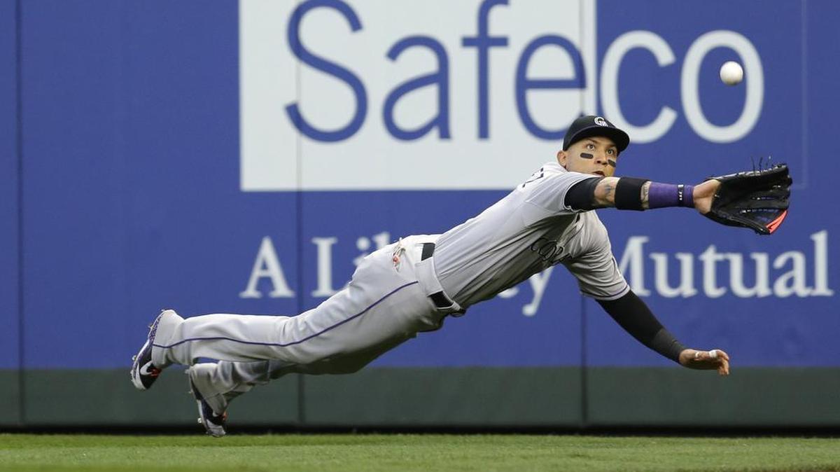 
Colorado Rockies right fielder Carlos Gonzalez dives to catch a ball hit by the Mariners’ Nelson Cruz for an out in the fourth inning Saturday.
