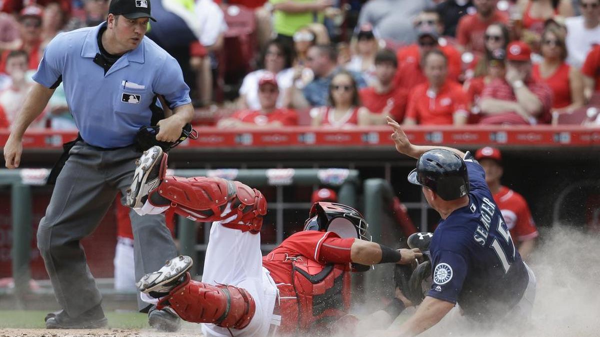 Seattle Mariners’ Kyle Seager (15) is tagged out by Cincinnati Reds catcher Ramon Cabrera, center, at home plate in the fifth inning Sunday, May 22, in Cincinnati.