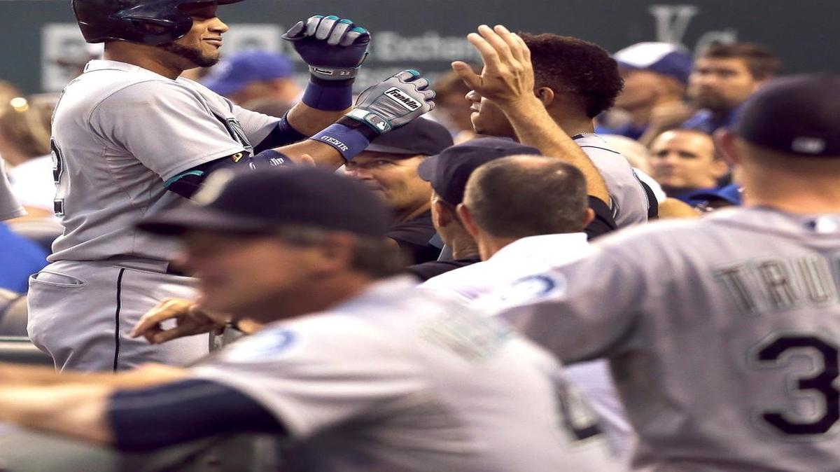 
The Mariners’ Robinson Cano celebrates with teammates after hitting a solo home run during the first inning in an 11-2 victory over the Kansas City Royals on Tuesday in Kansas City, Mo. Cano added a three-run homer in the fourth.
