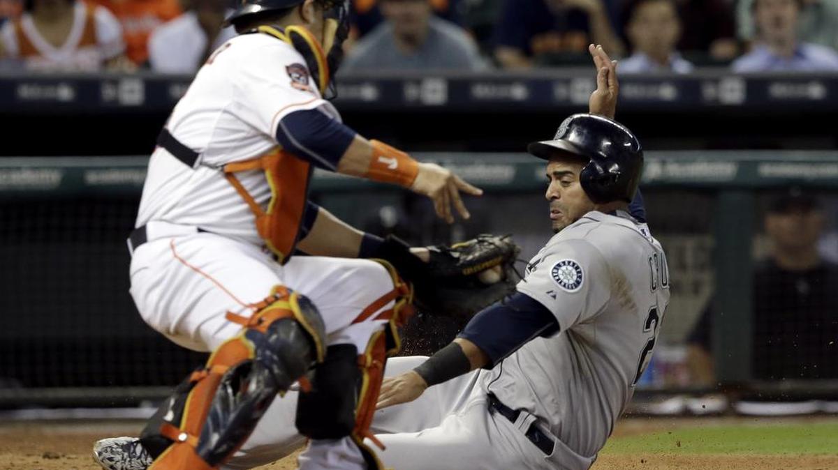 
Astros catcher Hank Conger tags Seattle’s Nelson Cruz out at home plate in the seventh inning on Wednesday. Cruz strained his quadriceps that inning while running the bases and will likely not play versus Oakland this weekend.
