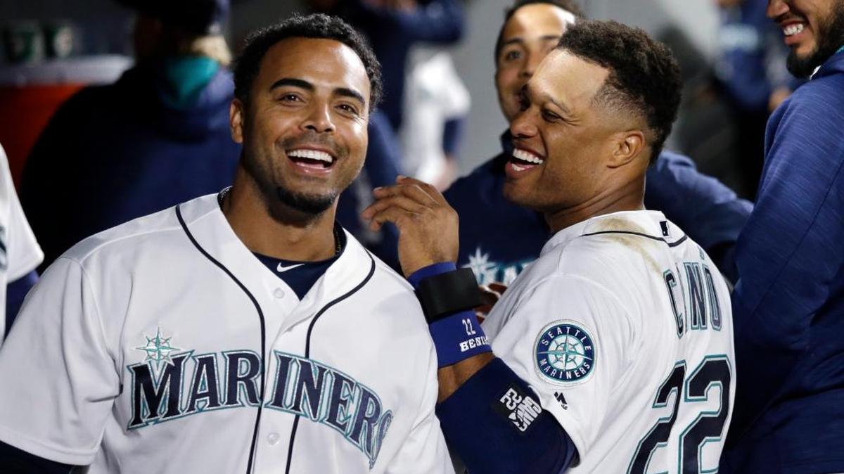 Seattle Mariners' Nelson Cruz, left, and Robinson Cano smiles in the dugout against the Houston Astros in a baseball game Tuesday, April 26, 2016, in Seattle.