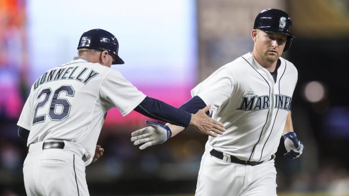
Mark Trumbo, right, is congratulated by third base coach Rich Donnelly after a two-run home run Wednesday against the Rangers.  Trumbo went 18-for-48 in a 12-game hitting streak that ended Friday.
