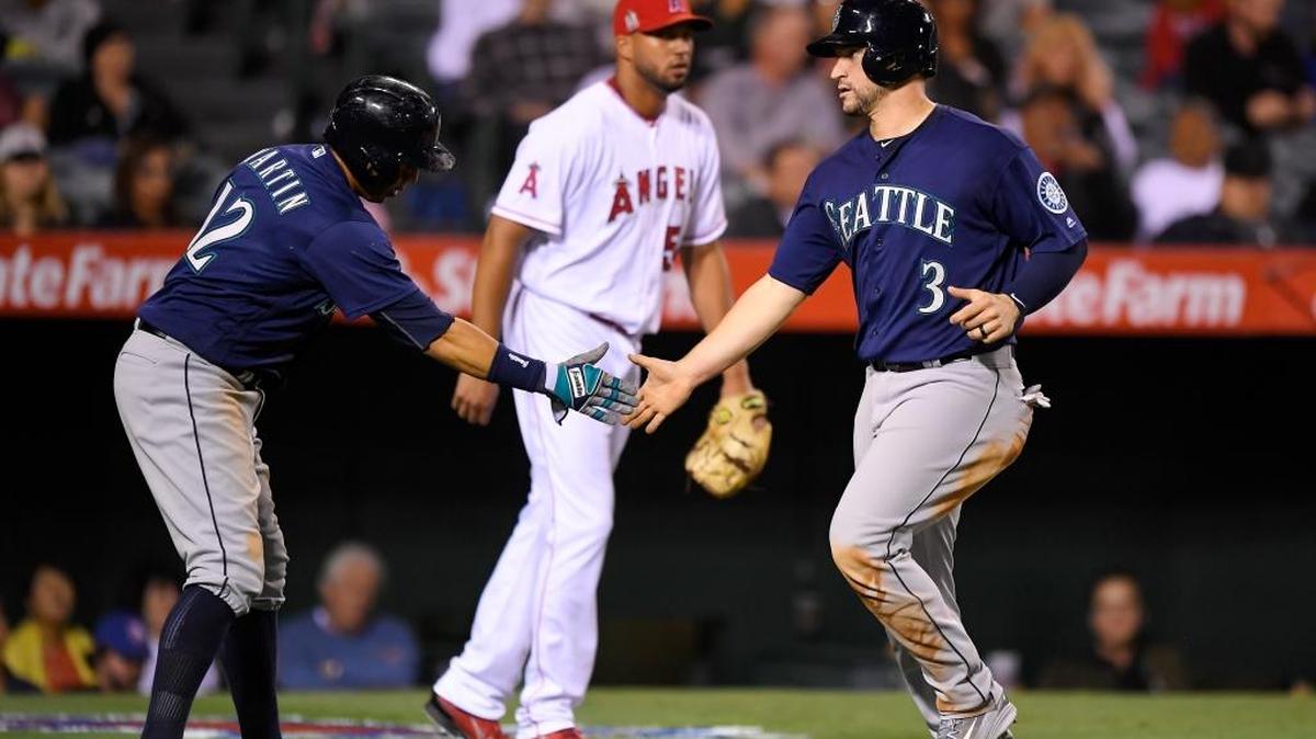 Seattle’s Leonys Martin, left, and Mike Zunino, right, congratulate each other after they scored on a single by Norichika Aoki, of Japan, as Los Angeles Angels relief pitcher Deolis Guerra looks on during the seventh inning of a baseball game, Monday, Sept. 12, 2016, in Anaheim, Calif. (AP Photo/Mark J. Terrill)