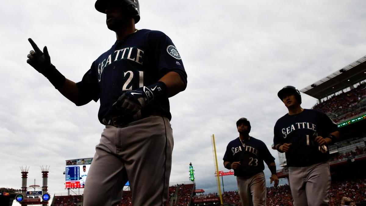 Seattle’s Franklin Gutierrez (21) leads Dae-Ho Lee, right, and Nelson Cruz, center right, into the dugout after hitting a three-run home run off Cincinnati Reds starting pitcher John Lamb on Saturday, May 21, in Cincinnati.