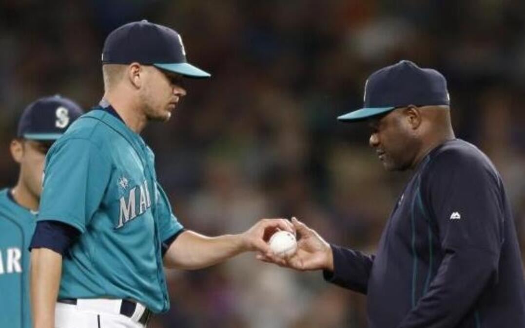 
Seattle Mariners manager Lloyd McClendon, right, takes the ball from relief pitcher Rob Rasmussen in the eighth inning of an 11-4 loss to the Chicago White Sox on Friday. The Mariners’ bullpen has the American League’s worst ERA since the All-Star break. 
