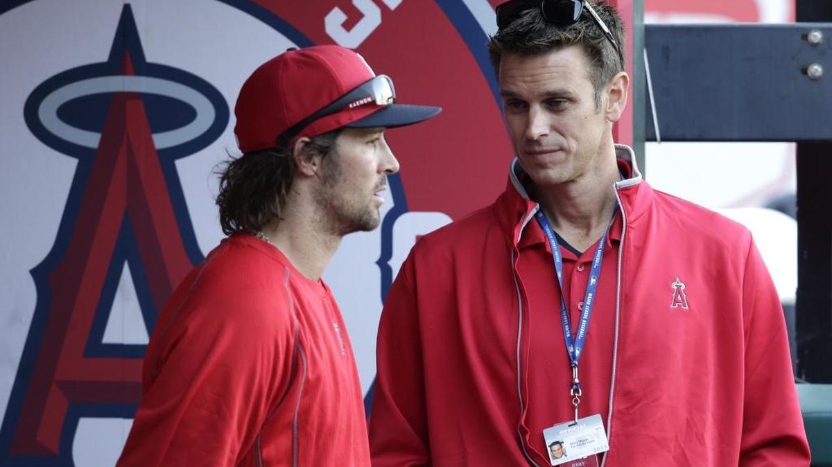 
Jerry Dipoto, right, talks with Angels starting pitcher C.J. Wilson before a game on April 11, 2015. 
